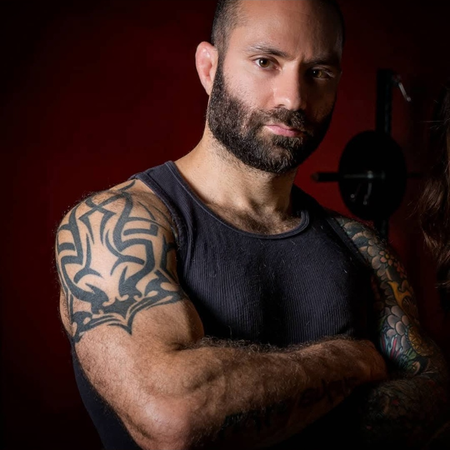 Steve, American Fitness coach, standing with crossed arms in the gym